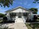 Charming home featuring a white exterior with blue accents, complemented by a well-manicured front yard at 14124 Plum Ln, Hudson, FL 34667