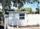 White storage shed with a small window and a lattice fence at 14124 Plum Ln, Hudson, FL 34667