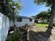 White storage shed with a garden bed and a blue metal roof at 14124 Plum Ln, Hudson, FL 34667