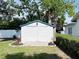 White storage shed with double doors and a blue metal roof at 14124 Plum Ln, Hudson, FL 34667