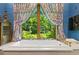 Bathroom with a large soaking tub under a picture window and decorative printed curtains at 3005 S Miller Rd, Valrico, FL 33596