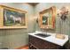 Charming powder room featuring a zebra painting, decorative mirror, and elegant lighting fixtures at 3005 S Miller Rd, Valrico, FL 33596