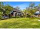 Exterior shot of the house showing a beautiful green lawn with professional landscaping and stone garages at 3005 S Miller Rd, Valrico, FL 33596