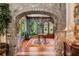 Elegant foyer with stone archway, hardwood floors, wood door, and decorative wallpaper at 3005 S Miller Rd, Valrico, FL 33596