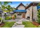 Stone front entrance with a blue awning, wood door, stone walkway, well manicured landscaping, and a grill at 3005 S Miller Rd, Valrico, FL 33596