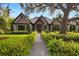 Charming front entry with gravel pathway, wooden door, stone facade and lush landscaping at 3005 S Miller Rd, Valrico, FL 33596