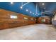 Spacious garage with wood paneled walls, blue ceiling, concrete floor, and natural light from windows at 3005 S Miller Rd, Valrico, FL 33596