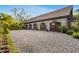 Detached four-car garage with gravel parking area, stone facade, and lush landscaping at 3005 S Miller Rd, Valrico, FL 33596