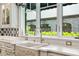 Close-up of a kitchen sink with marble countertops and a picturesque window view at 3005 S Miller Rd, Valrico, FL 33596