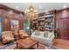 Comfortable living room with built-in bookshelves, wood paneling, and classic furniture at 3005 S Miller Rd, Valrico, FL 33596