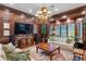 Elegant living room showcasing dark wood panels, chandelier, media center, and comfortable furniture at 3005 S Miller Rd, Valrico, FL 33596