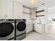Modern laundry room with stainless steel washer and dryer, white cabinets and a built-in sink at 531 Danube Ave, Tampa, FL 33606