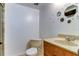 A bathroom featuring a toilet, a sink with a tan countertop, and a walk-in shower with marble-style tiling at 5396 Gulf Blvd # 110, St Pete Beach, FL 33706