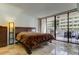 A bedroom with sliding glass doors opening to a balcony with views of the building across the street at 5396 Gulf Blvd # 110, St Pete Beach, FL 33706