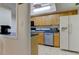 A functional kitchen design with wood cabinets and white appliances at 5396 Gulf Blvd # 110, St Pete Beach, FL 33706