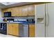 Kitchen with wood cabinets, blue countertops, and stainless steel appliances at 5396 Gulf Blvd # 110, St Pete Beach, FL 33706