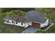 Aerial view of a modern home with a new gray roof, showcasing its architecture and spacious surroundings at 7425 245Th E St, Myakka City, FL 34251