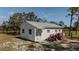 Quaint outbuilding with a metal roof and white siding, accented by a red tractor nearby at 7425 245Th E St, Myakka City, FL 34251