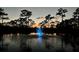 Scenic pond view at dusk featuring a fountain illuminated with blue light at 7425 245Th E St, Myakka City, FL 34251