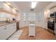 Bright kitchen with white cabinetry, granite countertops, and an island with breakfast area at 960 Starkey Rd # 3106, Largo, FL 33771