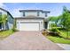 Charming two-story home with a brick driveway, well-manicured lawn, and a two-car garage at 10822 Windswept Garden Way, Tampa, FL 33647