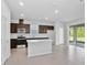 Bright kitchen with white countertops, stainless steel appliances, and a large window at 10822 Windswept Garden Way, Tampa, FL 33647