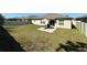 Wide view of the fenced backyard with a small patio and outdoor furniture by the back door at 10854 Sage Canyon Dr, Riverview, FL 33578
