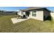 Grassy backyard features a patio with outdoor table set and grill, bordered by a white fence at 10854 Sage Canyon Dr, Riverview, FL 33578