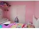 Pink bedroom features a double door closet, bed and net hanging from the ceiling at 10933 Subtle Trail Dr, Riverview, FL 33569