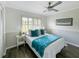 Bright bedroom with hardwood floors, ceiling fan, and sunlit window at 1123 Hounds Run, Safety Harbor, FL 34695