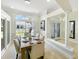 Elegant dining room with modern lighting, a stylish table, and views of the front yard at 1123 Hounds Run, Safety Harbor, FL 34695