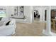 Neutral hallway leading from the living room to the dining room and featuring travertine flooring at 1123 Hounds Run, Safety Harbor, FL 34695