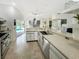 Bright kitchen featuring stainless steel appliances, stone countertops, and a seamless view to the outdoor pool area at 1123 Hounds Run, Safety Harbor, FL 34695