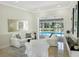 Bright living room with plush seating and sliding glass doors to a screened-in pool area at 1123 Hounds Run, Safety Harbor, FL 34695