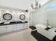 Bright main bathroom features dual sinks, a modern tub with tile surround, walk-in shower, and a large arched window at 1123 Hounds Run, Safety Harbor, FL 34695