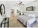 Main bedroom with tile flooring features a ceiling fan, ensuite bathroom and decor for a luxury experience at 1123 Hounds Run, Safety Harbor, FL 34695