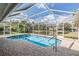 Inviting screened-in pool with brick patio and serene water views at 1123 Hounds Run, Safety Harbor, FL 34695