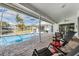 Inviting lanai with comfortable lounge seating and a pool with lake view at 1123 Hounds Run, Safety Harbor, FL 34695