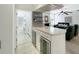 Elegant bar area featuring wine coolers, stone countertops, and convenient access to the laundry room and living area at 1123 Hounds Run, Safety Harbor, FL 34695