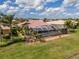 Aerial view of a home featuring a screened-in pool, set within a lush, green landscape at 16206 Diamond Bay Dr, Wimauma, FL 33598