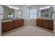 Primary bathroom with walk-in tub, dual sinks, and large mirrors at 16206 Diamond Bay Dr, Wimauma, FL 33598