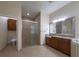 Bathroom featuring tiled floors, shower with glass door, wood vanity with sink, and toilet in separate alcove at 16206 Diamond Bay Dr, Wimauma, FL 33598