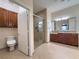 Bathroom featuring tiled floors, shower with glass door, wood vanity with sink, and toilet in separate alcove at 16206 Diamond Bay Dr, Wimauma, FL 33598
