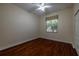 Bright bedroom with hardwood floors, ceiling fan, and large window offering natural light at 16206 Diamond Bay Dr, Wimauma, FL 33598