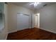 Bedroom with hardwood floors, ceiling fan, closet, and doorway to another room at 16206 Diamond Bay Dr, Wimauma, FL 33598