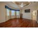 Large bedroom featuring a bay window, unique ceiling, ceiling fan, and mounted television at 16206 Diamond Bay Dr, Wimauma, FL 33598