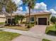 Charming home with a two-car garage, brick driveway, and lush landscaping at 16206 Diamond Bay Dr, Wimauma, FL 33598