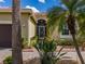 Exterior view of the front door with decorative screen and tropical landscaping at 16206 Diamond Bay Dr, Wimauma, FL 33598