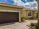 Exterior view of a two-car garage with a brick driveway and well-kept landscaping at 16206 Diamond Bay Dr, Wimauma, FL 33598