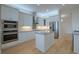 Modern kitchen with stainless steel appliances, a kitchen island, and custom cabinets at 16206 Diamond Bay Dr, Wimauma, FL 33598